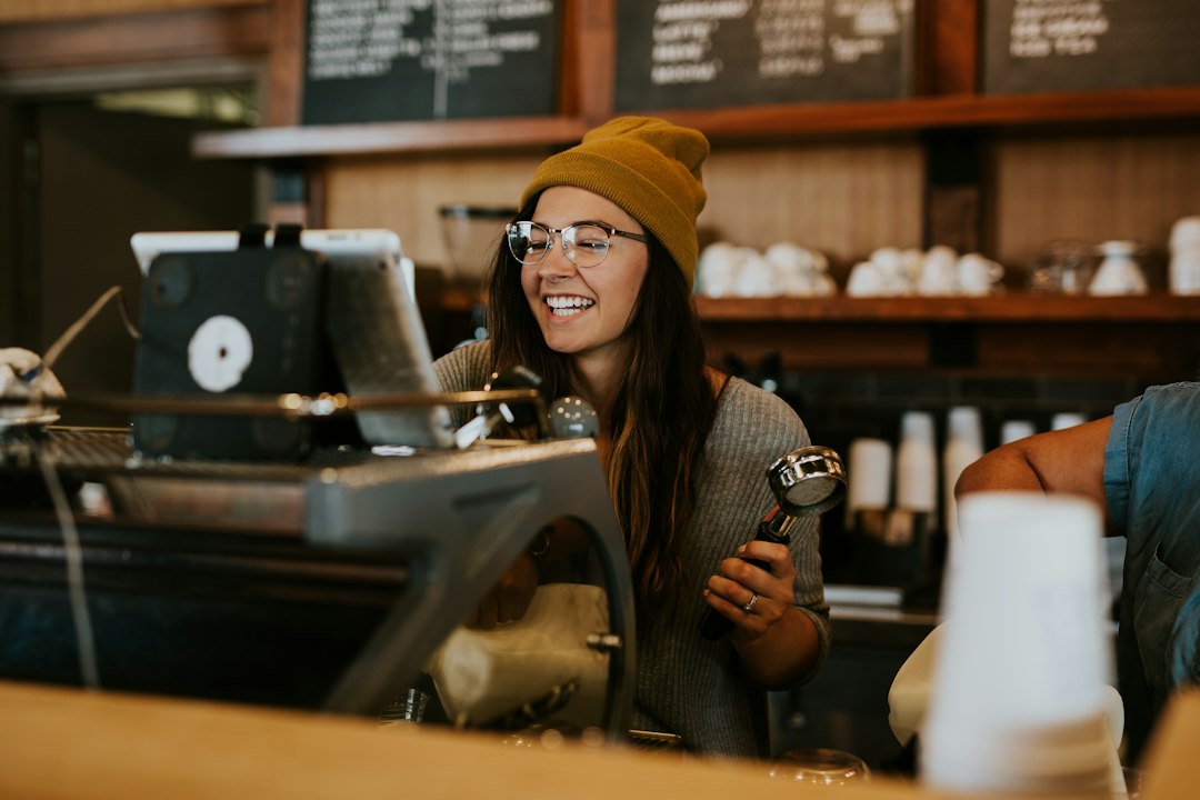 Barista sonriente atendiendo en su cafetería, ejemplo de fidelización de clientes