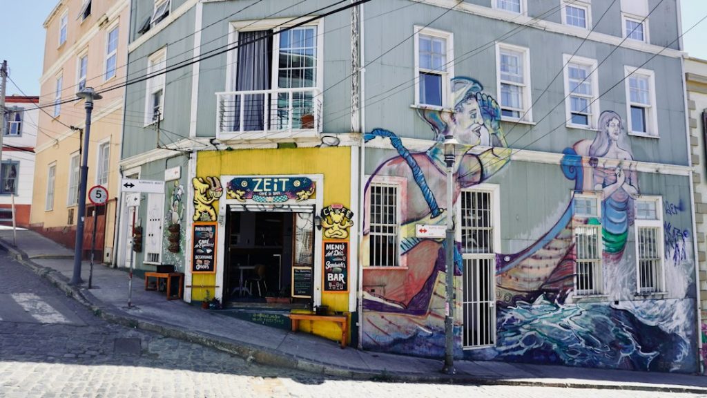 Café con fachada amarilla y murales en una esquina empedrada, negocios para emprender en Chile