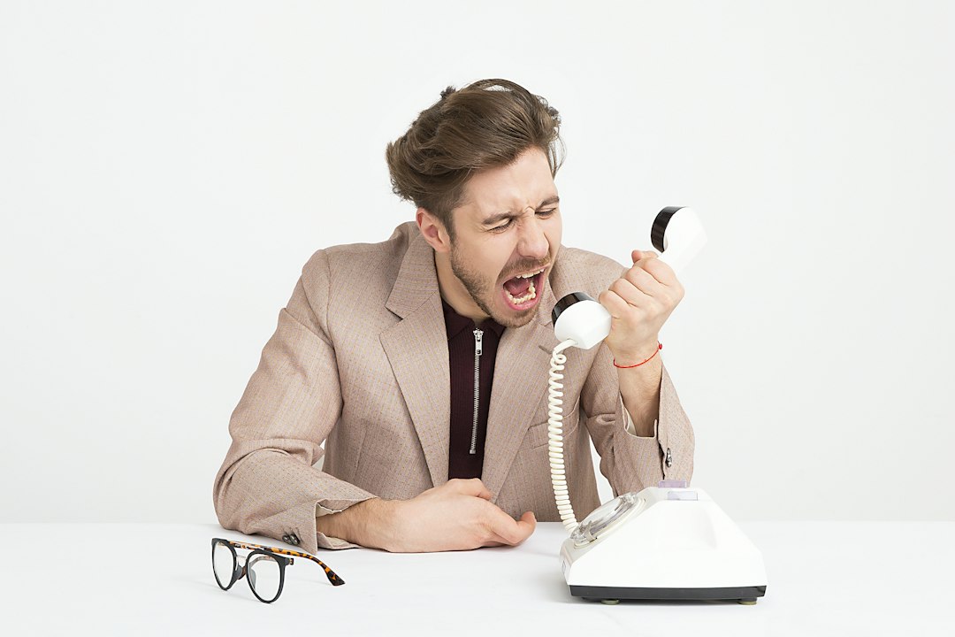 Cliente difícil gritando al teléfono durante una llamada de reclamación