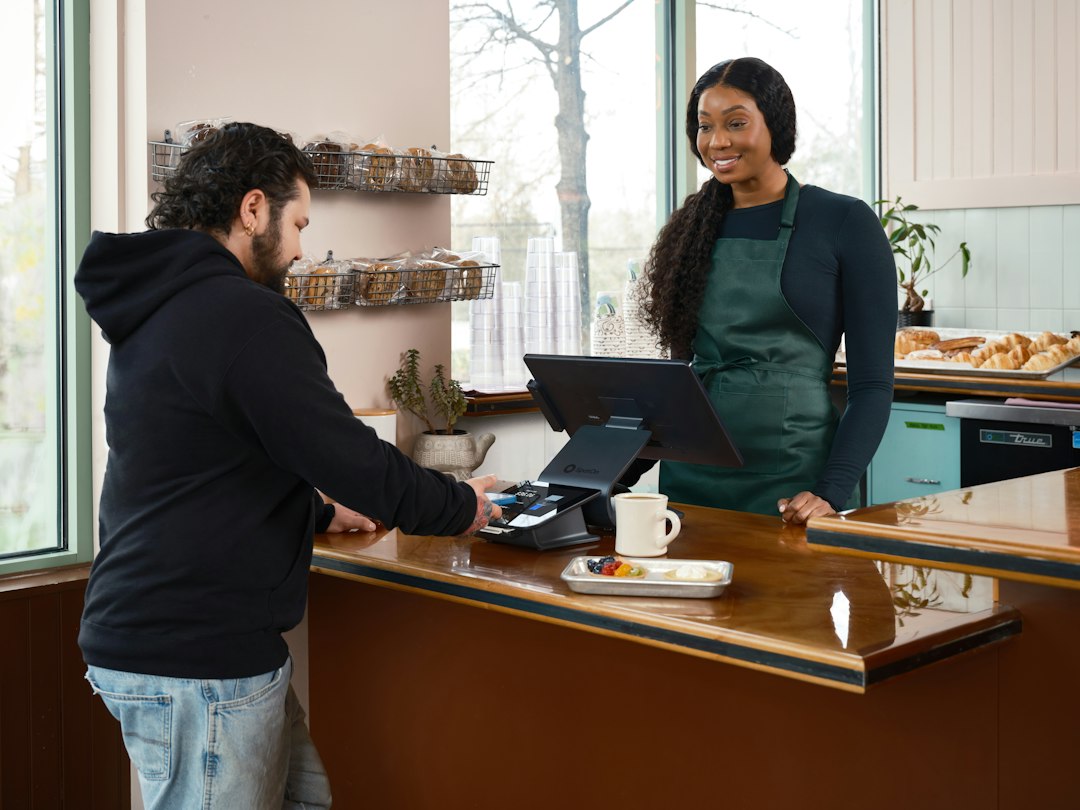 Cliente habitual pagando en una cafetería, ejemplo del valor del ciclo de vida del cliente