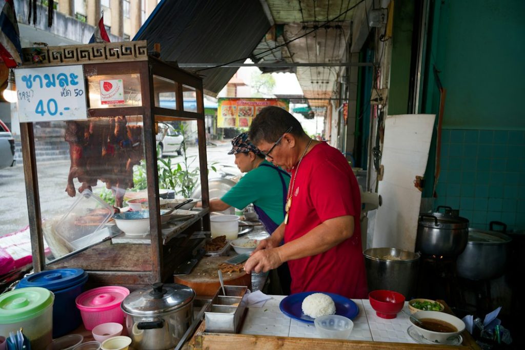 Dos personas preparan comida en un puesto callejero, negocios que puedes empezar con menos de 100 dólares
