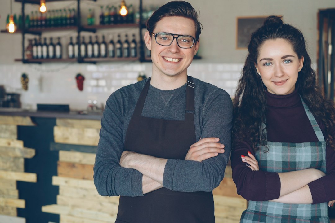 Dueños de una cafetería sonriendo en su negocio, cómo generar confianza en tus clientes