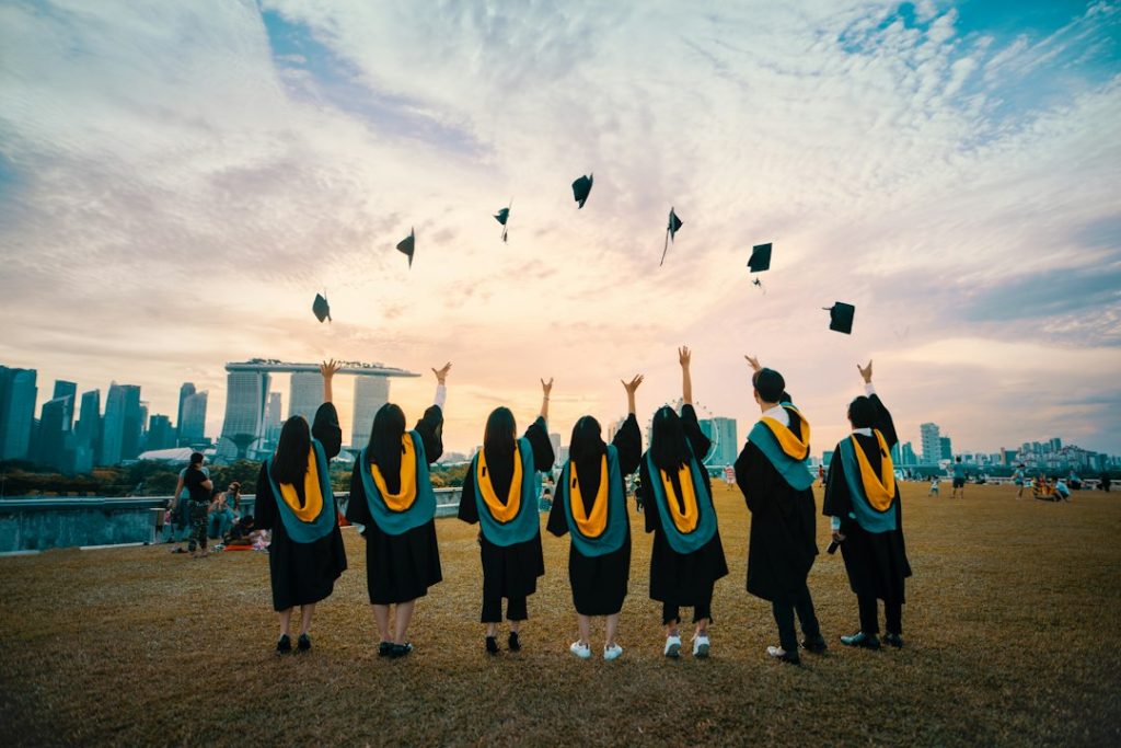 Graduados lanzando sus birretes, becas para colombianos para estudiar en el extranjero
