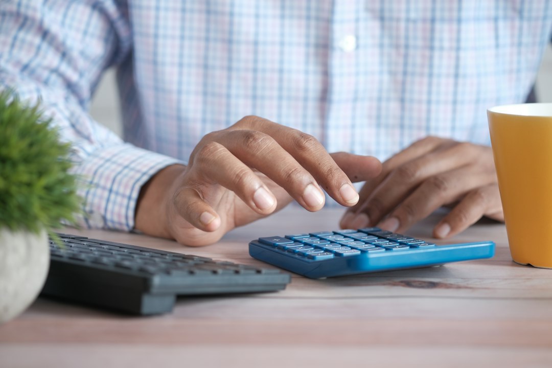 Persona calculando las cuotas de un préstamo en línea con una calculadora