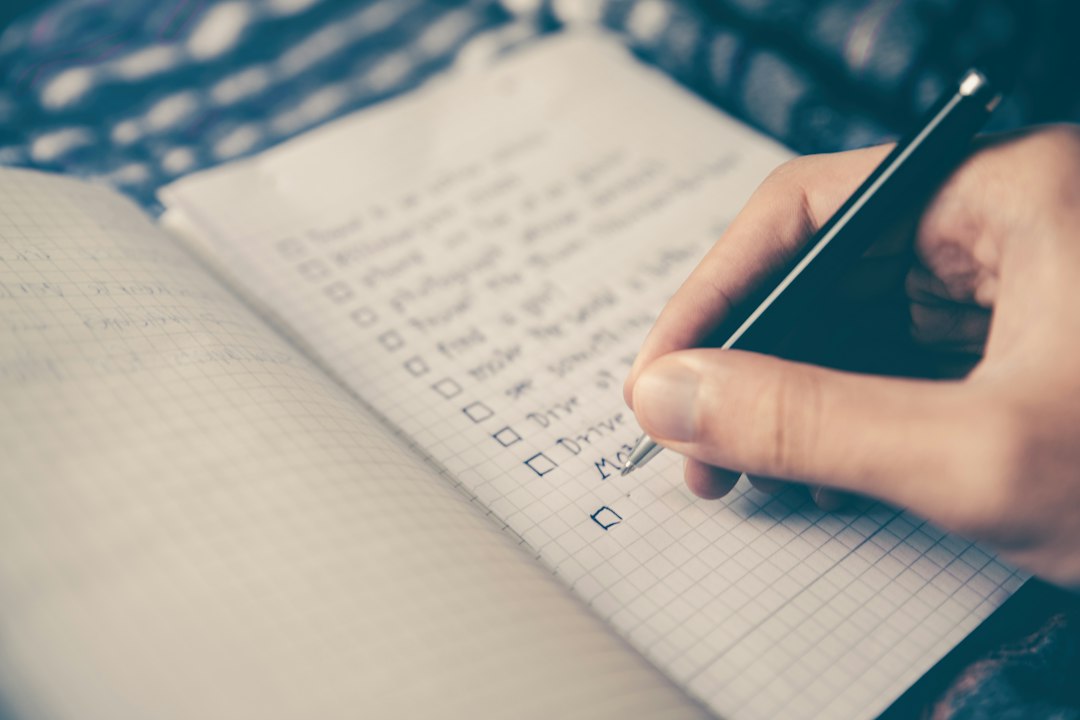 Persona escribiendo sus metas en una libreta para hacer un análisis FODA personal