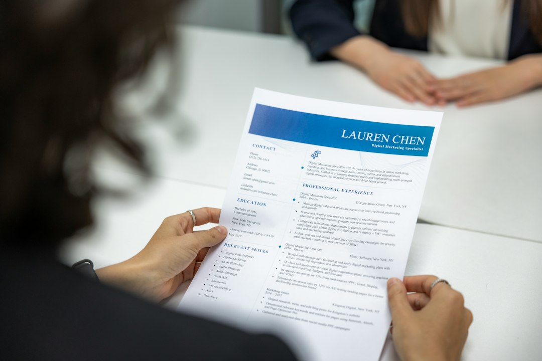 Reclutadora leyendo un currículum vitae impreso en una mesa